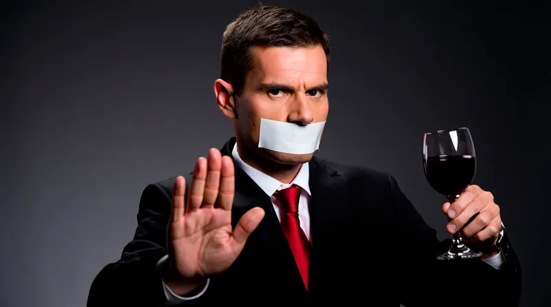 Мужчина показывает жест отказа от алкоголя